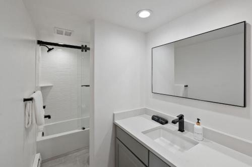 Un baño blanco con lavabo y espejo. en Vail International Unit 207, en Vail