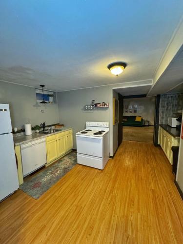 a kitchen with white appliances and a wooden floor at Schillhaus Lvl 1 in Louisville