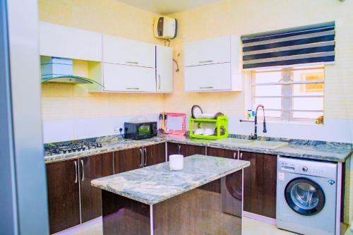 a kitchen with a sink and a washing machine at Dej's Luxury Apartment House 1 in Lekki