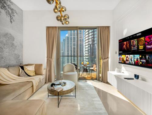 a living room with a couch and a tv at SmartStay at Grande Signature - Downtown Dubai City Views - Brand New Luxury Apartments in Dubai