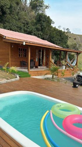 a house with a swimming pool with frisbees in it at Sítio vale das pedras in Barracão