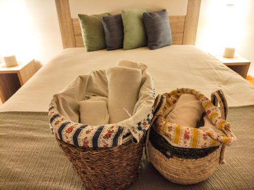 two baskets sitting on the floor next to a bed at Casa de Campo Vale do Ceira in Góis