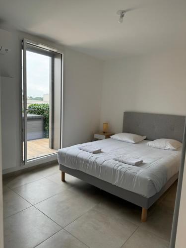 ein Schlafzimmer mit einem Bett und einem großen Fenster in der Unterkunft Colocation appartement terrasse XXL Port Marianne in Montpellier