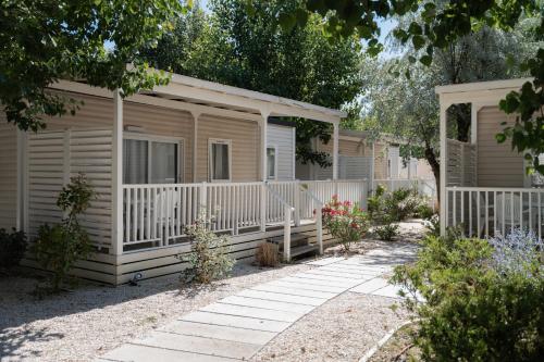 a home with a porch and a white fence at Club del Sole Romagna Family Resort in Riccione