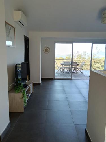 - un salon avec vue sur une table et une terrasse dans l'établissement Villa en Corse du Sud - Golf d'Ajaccio, à Coti-Chiavari