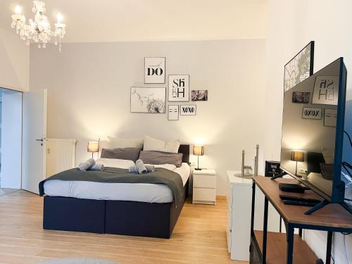 a bedroom with a bed and a desk and a television at Qonroom - as individual as you - Oeynhausen City in Bad Oeynhausen
