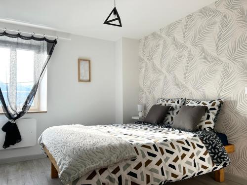 - une chambre blanche avec un lit et un mur dans l'établissement La Source du Bonheur-Clim Parking Wifi - CLG Savoie, à Saint-Pierre-dʼAlbigny