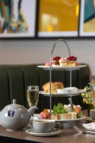 a table with three tiers of food and a teapot at Holiday Inn London Gatwick - Worth by IHG in Crawley
