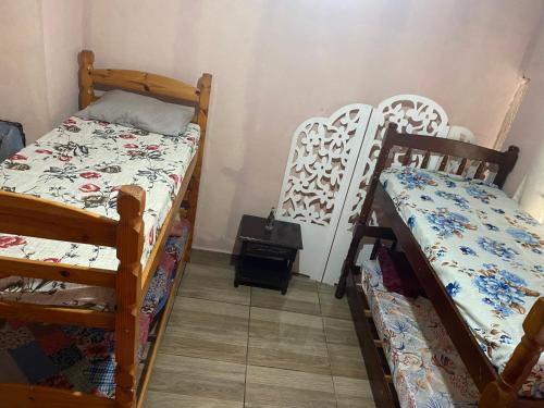 a room with two bunk beds and a table at Encontro dos passaros in Sarapuí