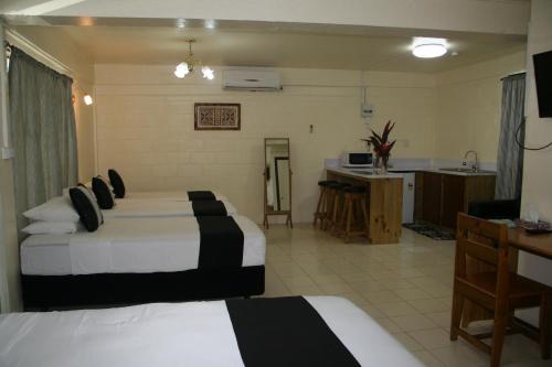 a hotel room with two beds and a kitchen at Moatoga Hotel in Apia