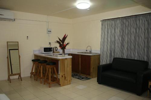 a kitchen with a counter and a sink and a chair at Moatoga Hotel in Apia