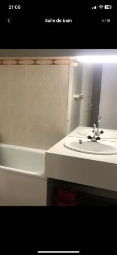 une salle de bain avec un lavabo, une baignoire et un miroir dans l'établissement Studio cosy au bord des pistes à la mongie, à Bagnères-de-Bigorre