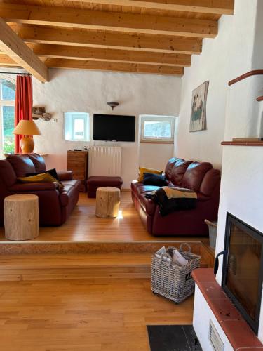 a living room with leather furniture and a flat screen tv at Ferienhaus am Schloß in Malberg