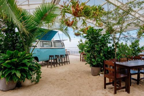 a tent with tables and chairs and a van in the sand at Blue Nun at 29, City Views and Wonderland Vibes! in Hatillo