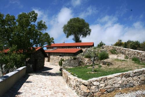 a house with a stone wall next to a building at Abrigo de Montanha in Montalegre