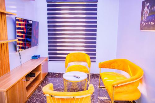 two yellow chairs and a table in a room at Dej's Luxury Apartment House in Lekki