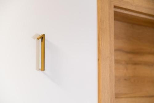 a door with a brass handle on a white wall at Hiša S'TJE Ljubljana Airport in Cerklje na Gorenjskem