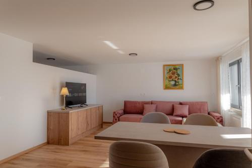 a living room with a couch and a table at Hiša S'TJE Ljubljana Airport in Cerklje na Gorenjskem