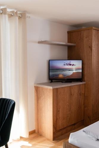 a television sitting on a wooden stand in a room at Hiša S'TJE Ljubljana Airport in Cerklje na Gorenjskem