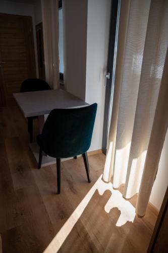 a chair and a table in a room with a window at Hiša S'TJE Ljubljana Airport in Cerklje na Gorenjskem
