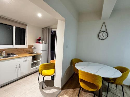 a kitchen with a table and yellow chairs in a room at Smart Deluxe Studio N9 private Kitchenette Balcony Beach 250m Marina Port 900m in Limassol