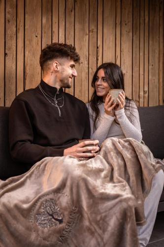 a man and a woman sitting on a couch at Jaggling Appartements in Sankt Ulrich am Pillersee