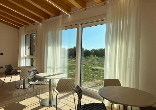 a room with tables and chairs and a large window at Agriturismo B&B Lombardi Bologna - San Lazzaro in La Mura
