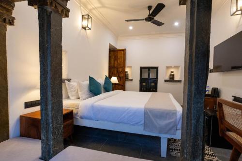 a bedroom with a bed and a ceiling fan at Madri Retreat - Heritage Boutique Hotel with Pool in Udaipur