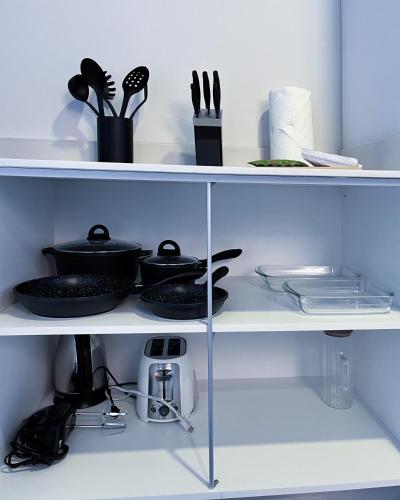 a shelf with dishes and utensils on it at Serenity at 12, City Views and Wonderland Vibes! in Hatillo
