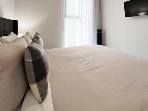 a bedroom with a bed with white sheets and pillows at Serenity at 12, City Views and Wonderland Vibes! in Hatillo