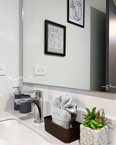a bathroom with a sink with a mirror and towels at Serenity at 12, City Views and Wonderland Vibes! in Hatillo