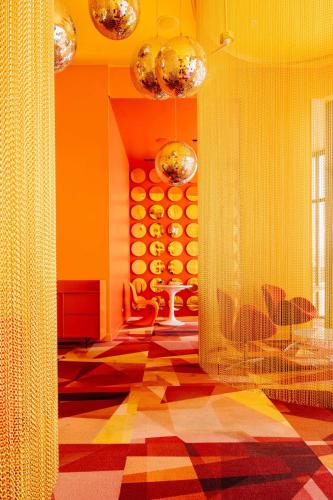 a living room with orange walls and a checkered floor at Serenity at 12, City Views and Wonderland Vibes! in Hatillo