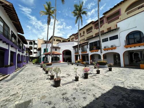 a courtyard with potted plants and palm trees at Departamento cerca a la Playa in Puerto Vallarta