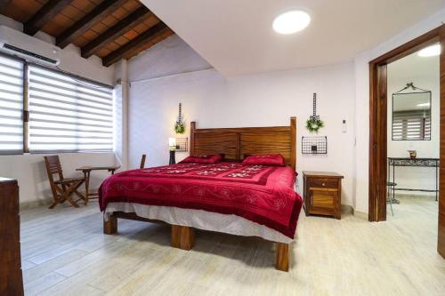 a bedroom with a large bed with a red blanket at Departamento cerca a la Playa in Puerto Vallarta