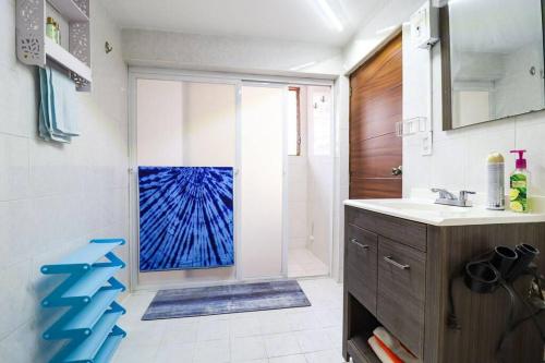 a bathroom with a sink and a shower with a blue window at Departamento cerca a la Playa in Puerto Vallarta