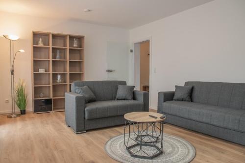 a living room with two couches and a table at Prime 47 - Neuwertige Wohnung in Schlüsselfeld