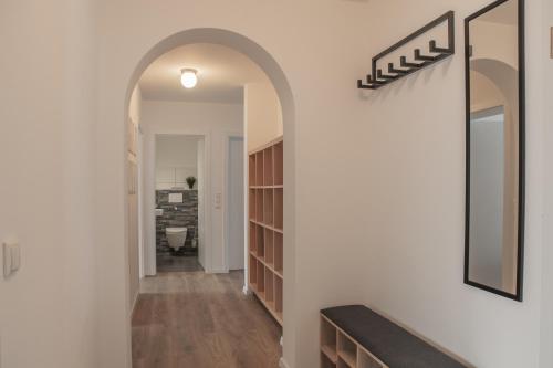 a hallway with an archway and a mirror on the wall at Prime 47 - Neuwertige Wohnung in Schlüsselfeld