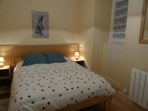 une chambre avec un lit avec une couette noire et blanche dans l'établissement Gite Chez Picou, à La Tour-dʼAuvergne