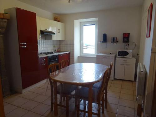 une cuisine avec une table en bois et une table et des chaises dans l'établissement Gite Chez Picou, à La Tour-dʼAuvergne