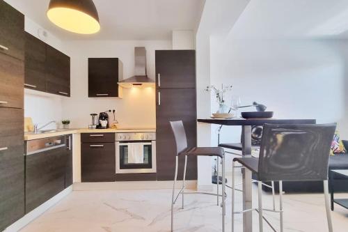 une cuisine avec une table et quelques chaises dans l'établissement NEW - Le Modern One at Swiss border, à Saint-Louis