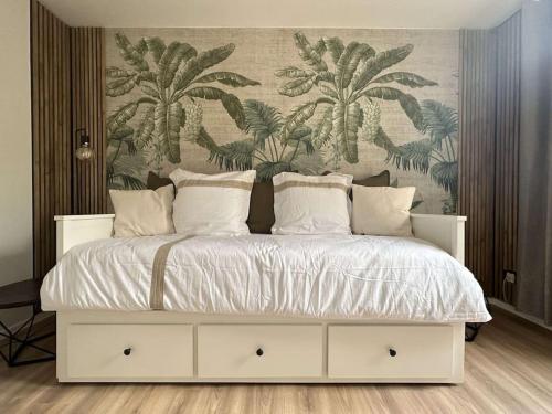 - une chambre avec un lit blanc et un papier peint floral dans l'établissement Appartement les Lilas, à Dijon