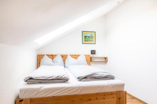 a bedroom with a bed with white sheets and pillows at Schönbergbauer in Schönberg