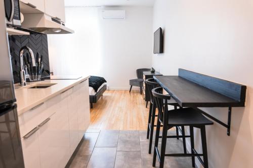 a kitchen with a black table and some chairs at #3 - Chic Studio - Self Check in - Plateau - St-Denis - AC - TV in Montréal