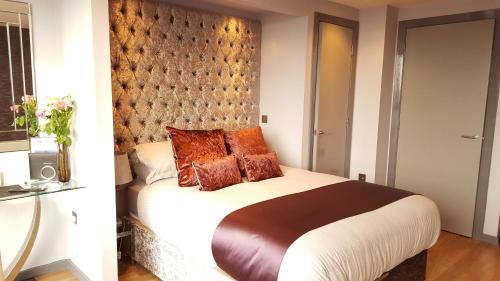 a bedroom with a large bed with brown pillows at City Atmosphere in Leeds