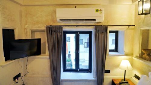 a room with a window with a air conditioner on the wall at Madri Retreat - Heritage Boutique Hotel with Pool in Udaipur