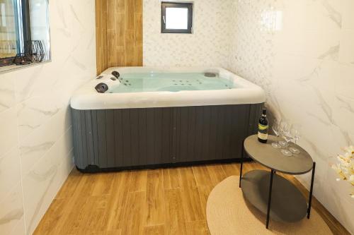 a bath tub in a room with a table at Lavalliere Hotel & Villas in Sarnitsa
