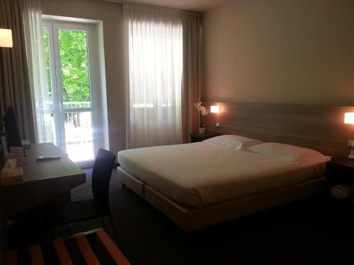a hotel room with a bed and a window at HLL Hotel Lungolago Lecco-Como Lake in Lecco