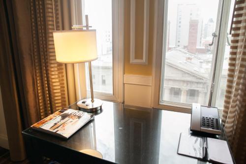a lamp on a desk in a room with a window at The Pickwick Hotel San Francisco in San Francisco
