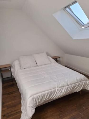 un lit blanc dans une chambre avec une fenêtre dans l'établissement Gite Jalagnat Plaisir Creusois, à Faux-la-Montagne