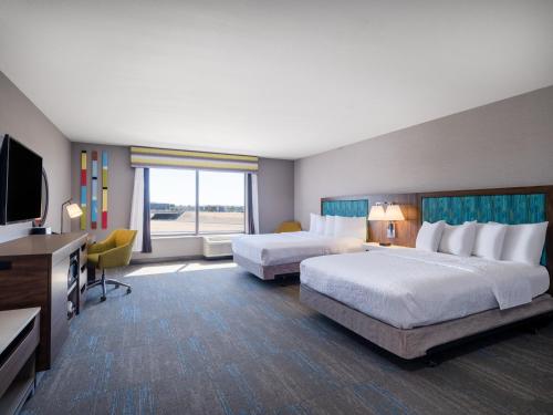 a hotel room with two beds and a flat screen tv at Hampton Inn & Suites Boise-Meridian in Meridian